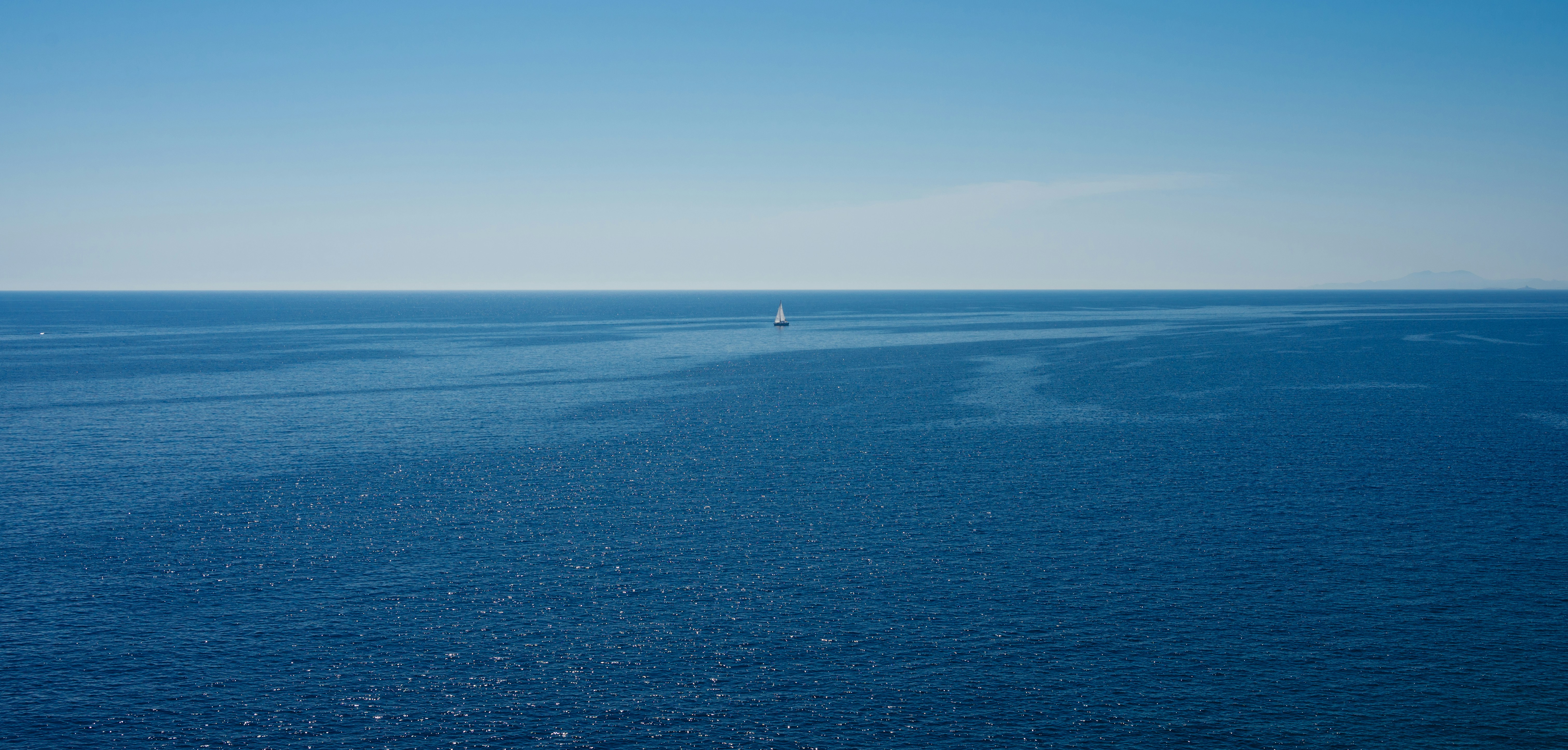 A large body of water with a boat in the distance