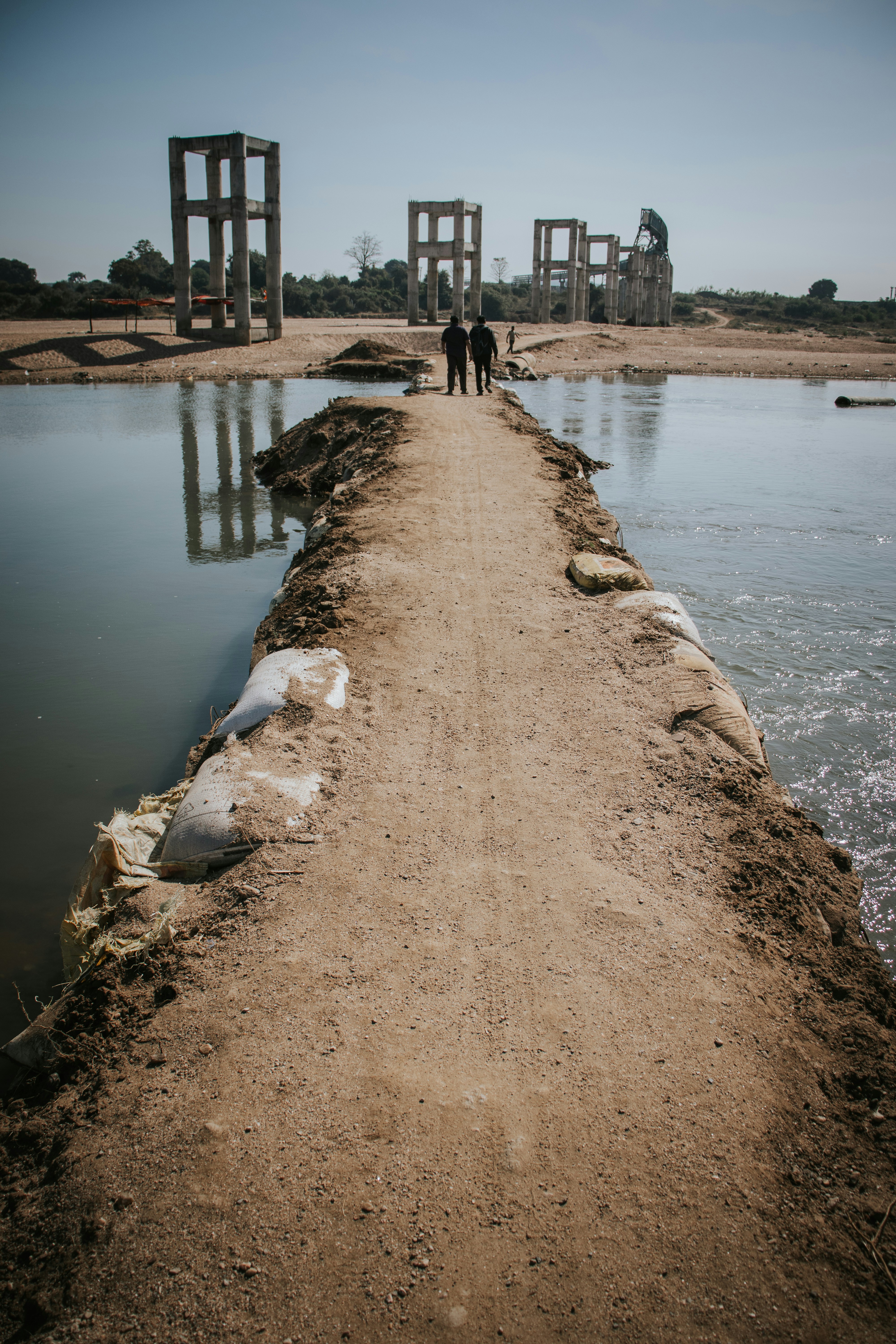 Two people standing on a bridge over a body of water