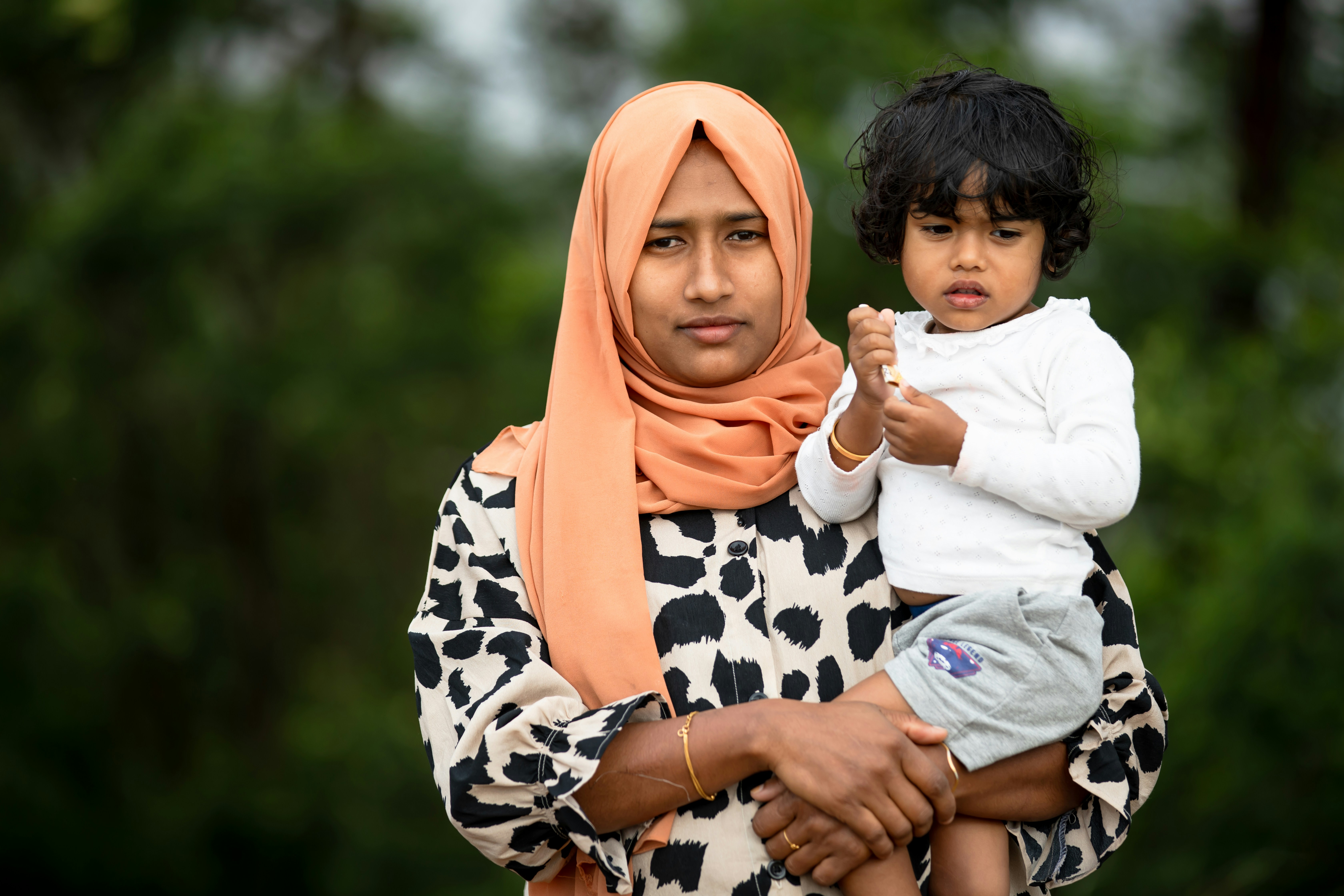 Seorang wanita menggendong seorang anak di pelukannya