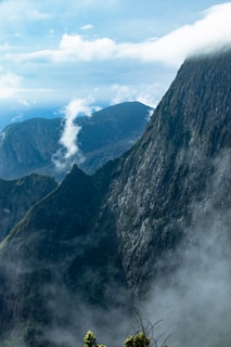 A view of a mountain range with clouds in the sky