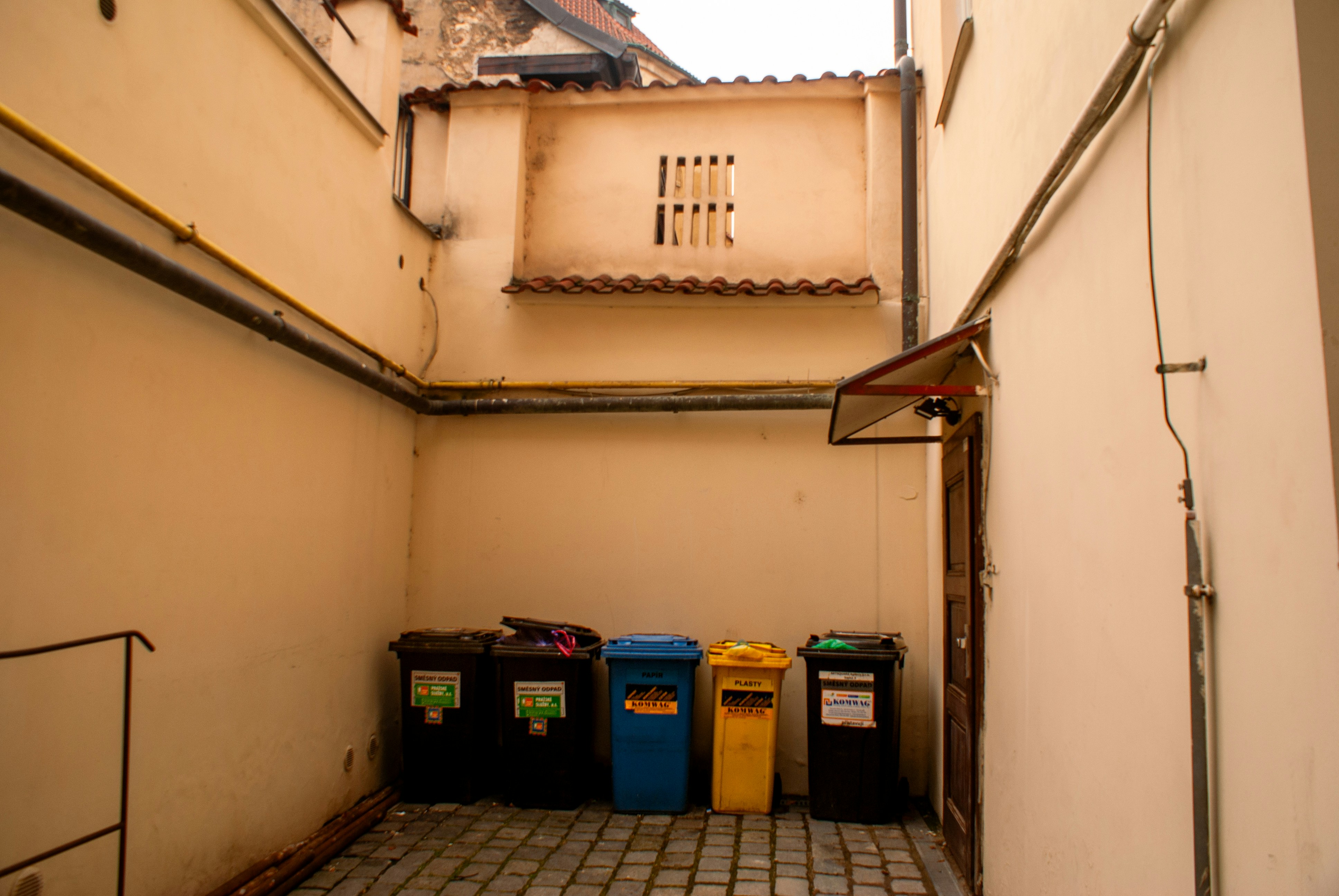 A narrow alley way with trash cans on the floor