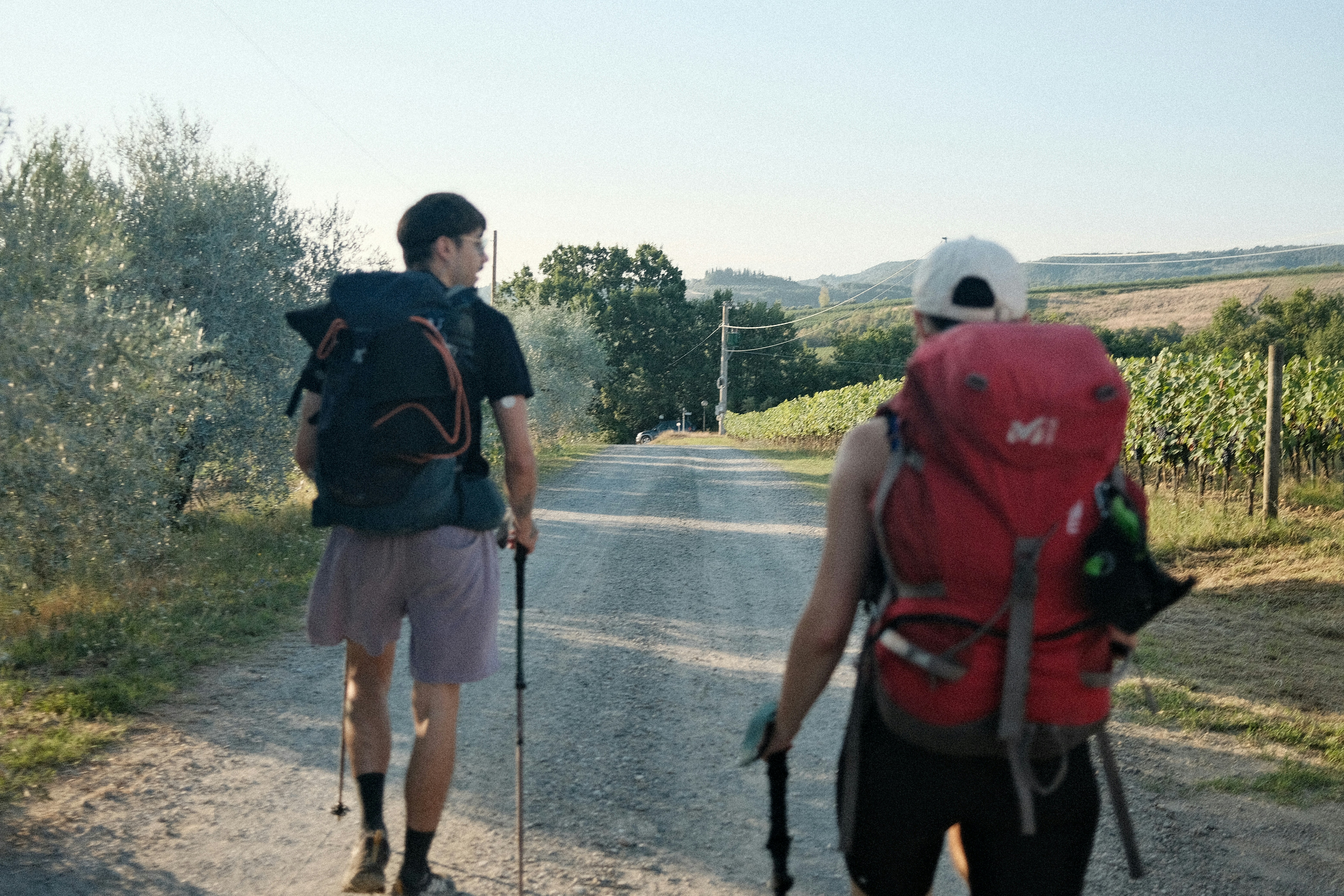 A couple of men walking down a dirt road