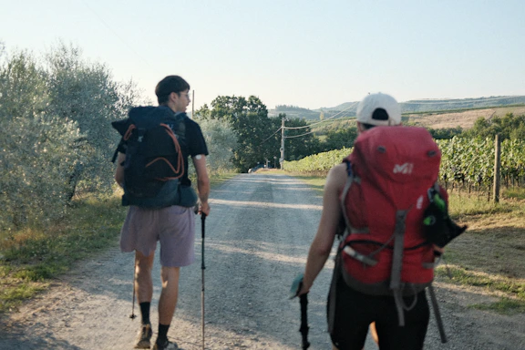 A couple of men walking down a dirt road