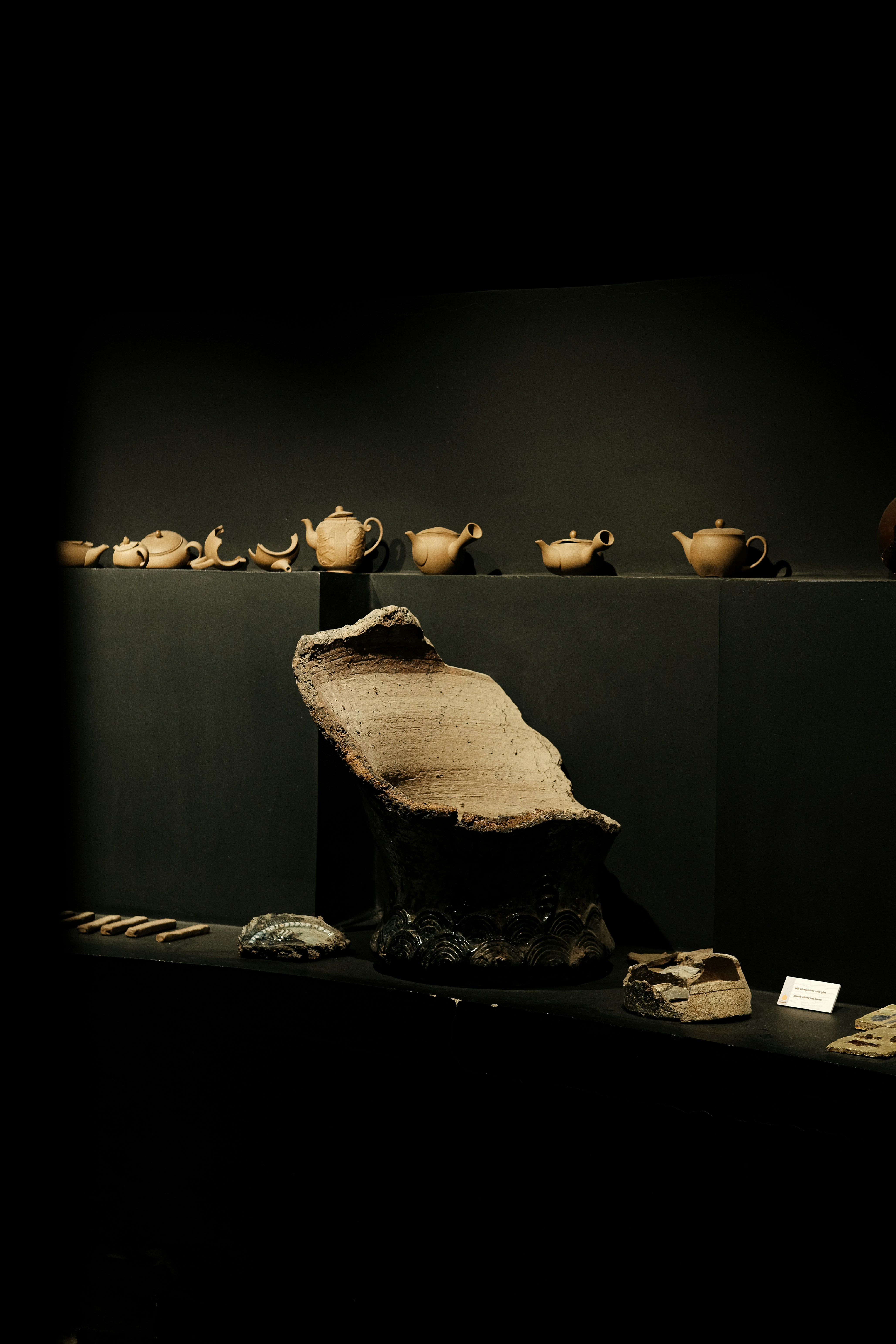 A display of pottery in a dark room