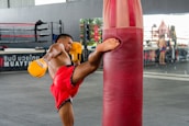 A man standing next to a punching bag
