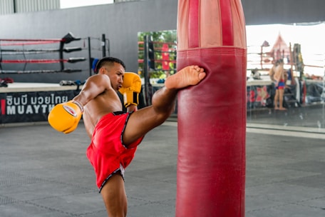 A man standing next to a punching bag