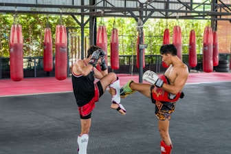 A couple of men standing next to each other in a gym