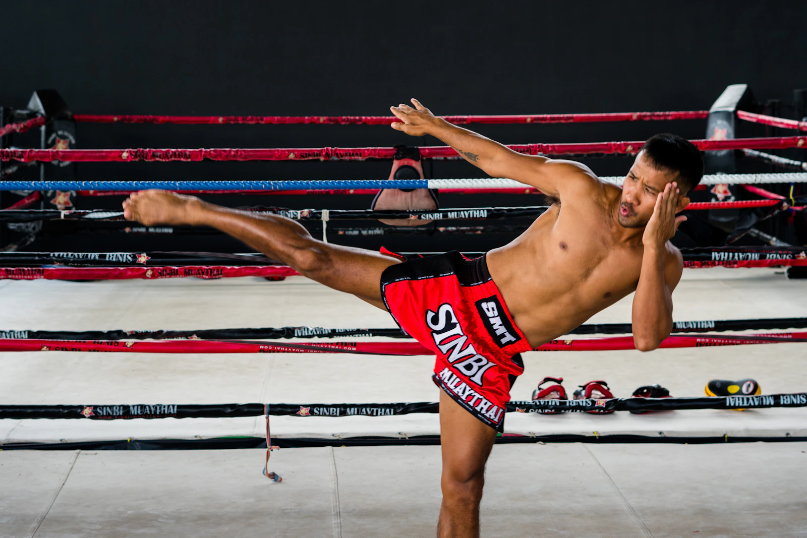 A fighter throwing a kick during training in a Bangkok gym