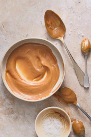 A bowl of peanut butter and spoons on a table