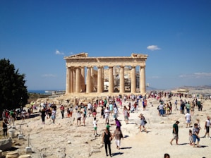 A group of people standing around a building on top of a hill