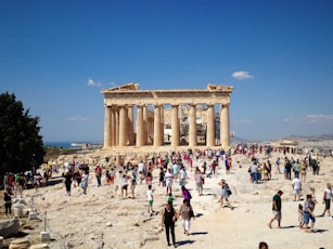 A group of people standing around a building on top of a hill