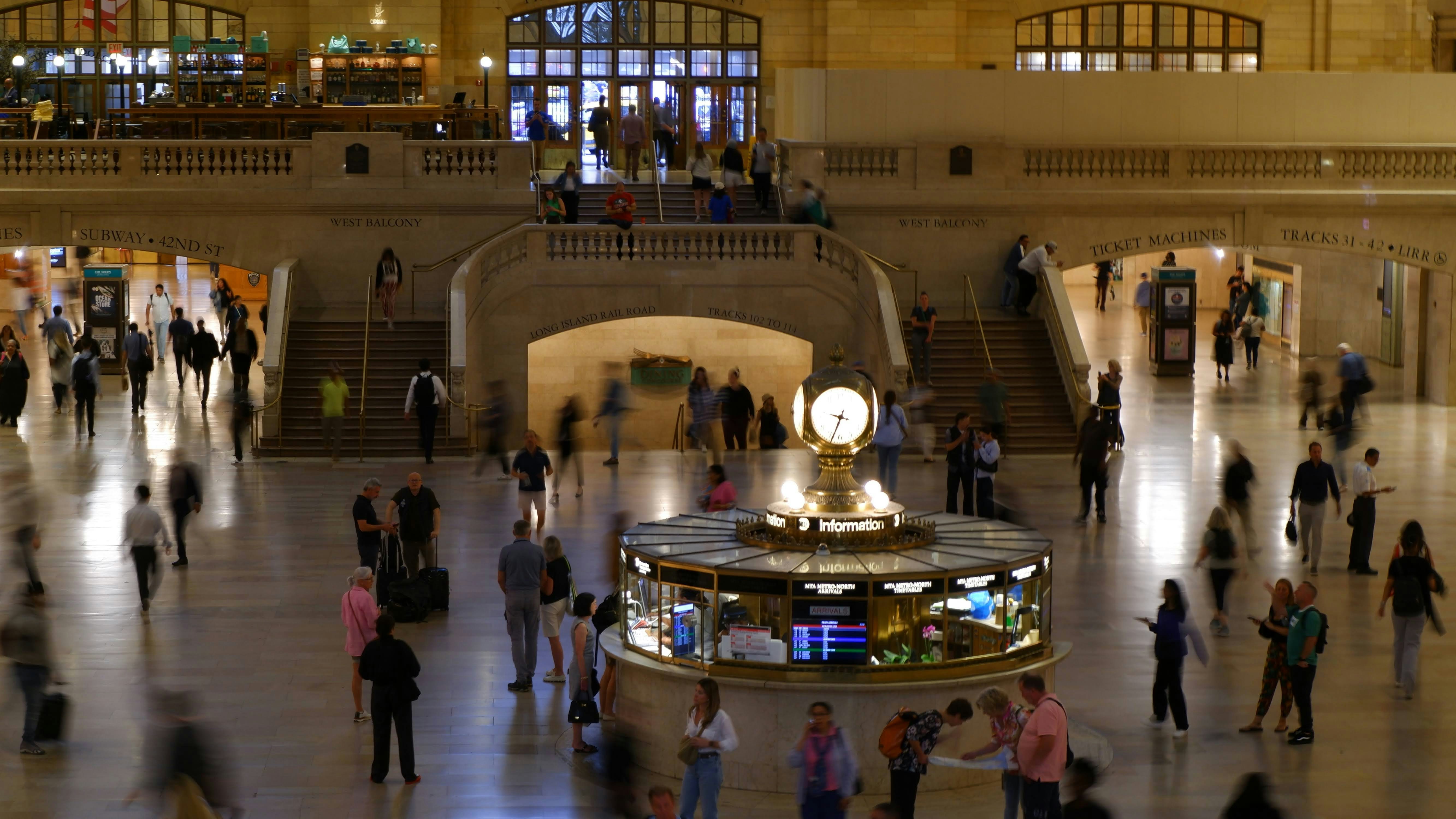Un gran grupo de personas caminando alrededor de un edificio