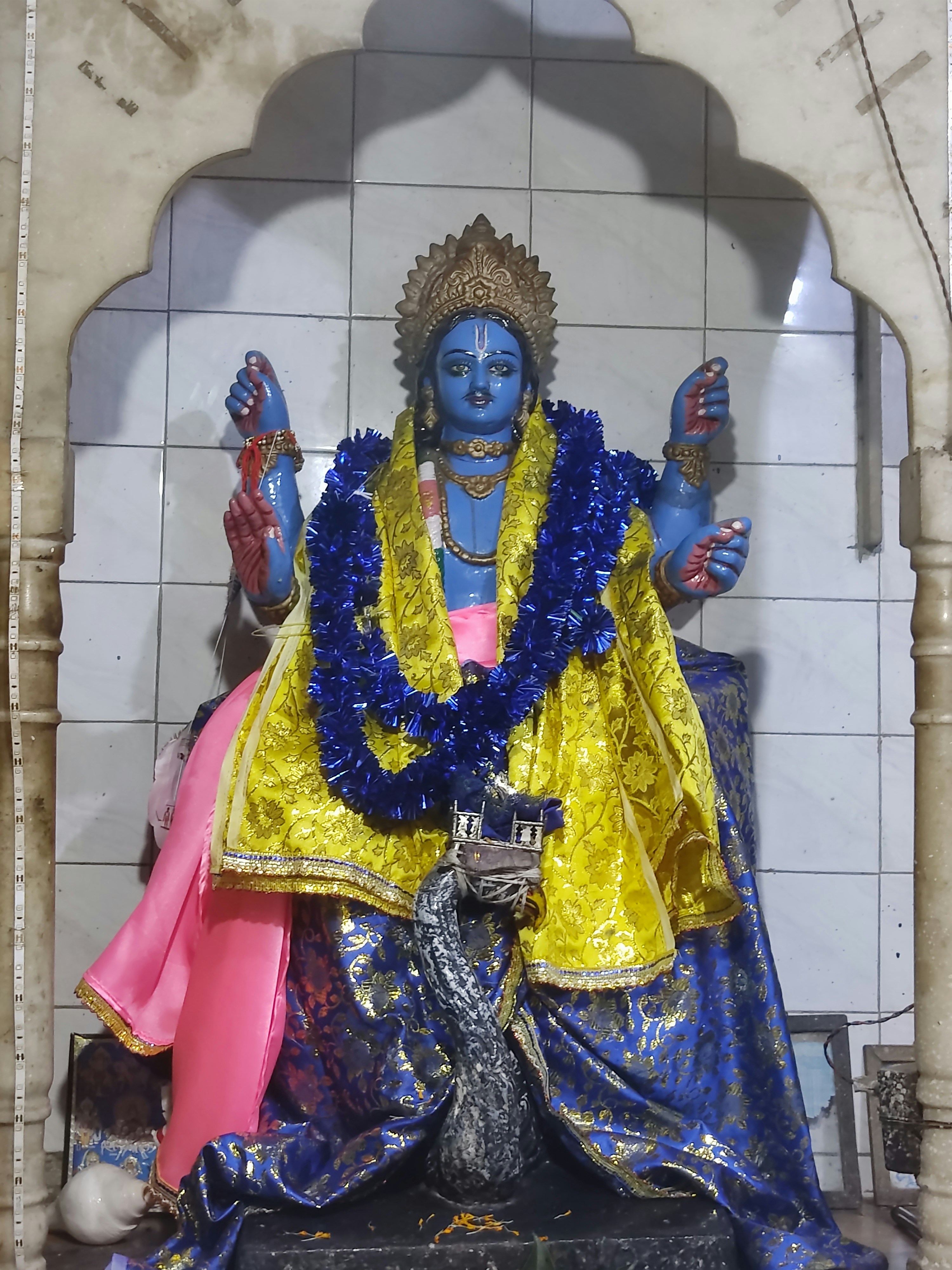 Patung seseorang dengan pakaian kuning dan biru