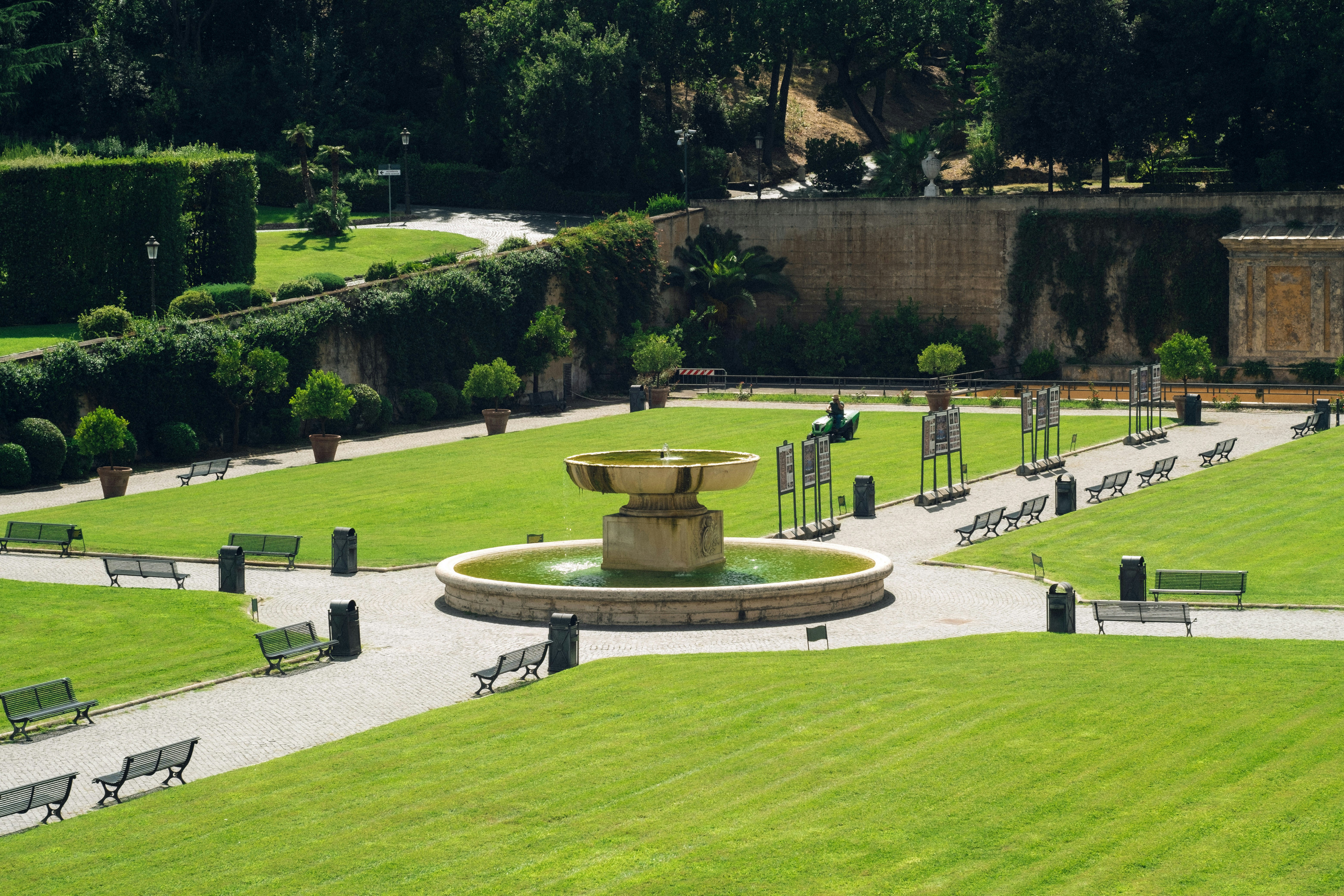 Um jardim com uma fonte cercada por bancos