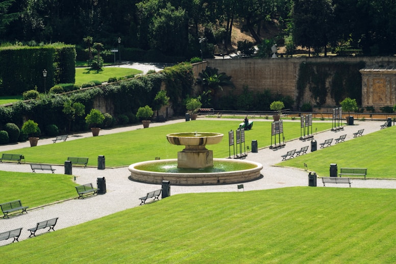 A garden with a fountain surrounded by benches