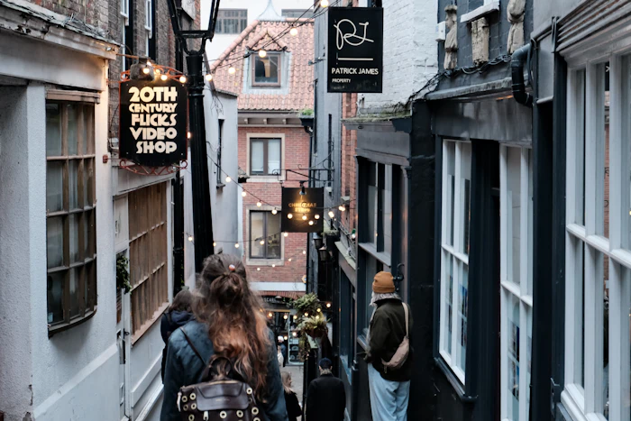 People walking along a narrow Bristol street, the kind of neighbourhood people search when browsing Bristol dating sites free of charge