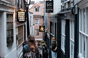 A couple of people walking down a narrow street