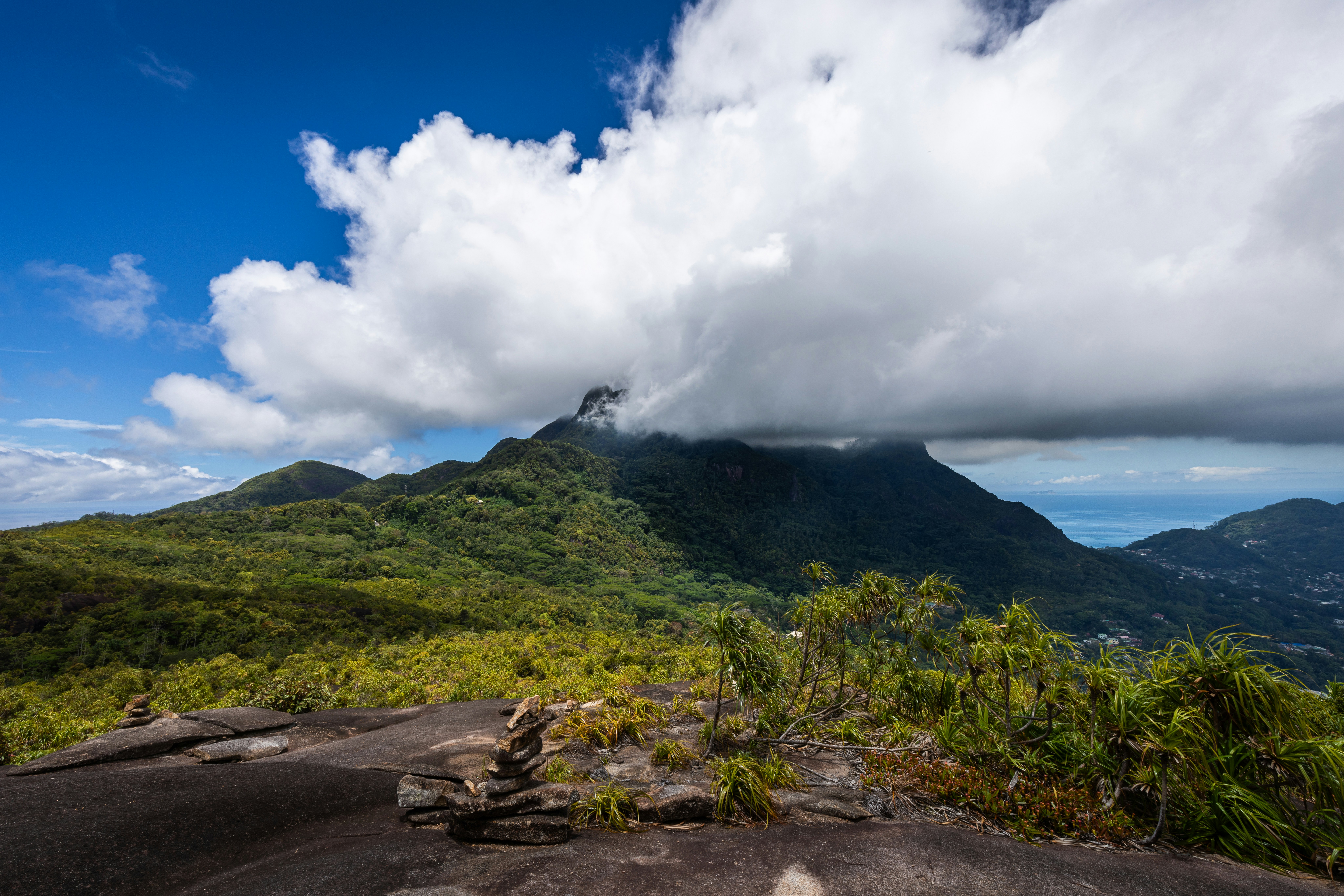 A view of a mountain with a cloud in the sky