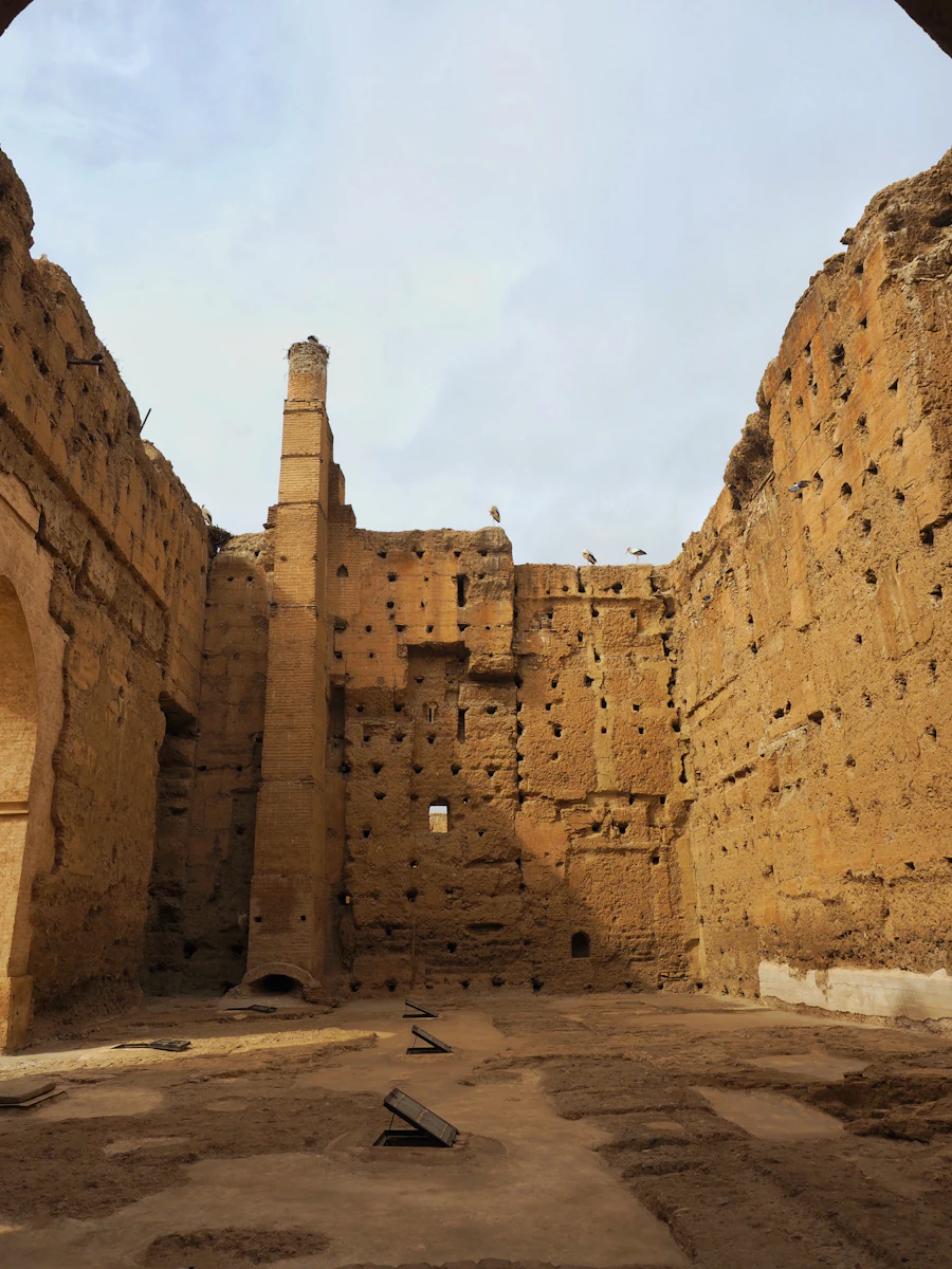The towering rammed-earth walls of the ruined El Badi Palace in the Marrakech Kasbah, with storks nesting along the top