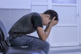 A man sitting on a chair with his head in his hands