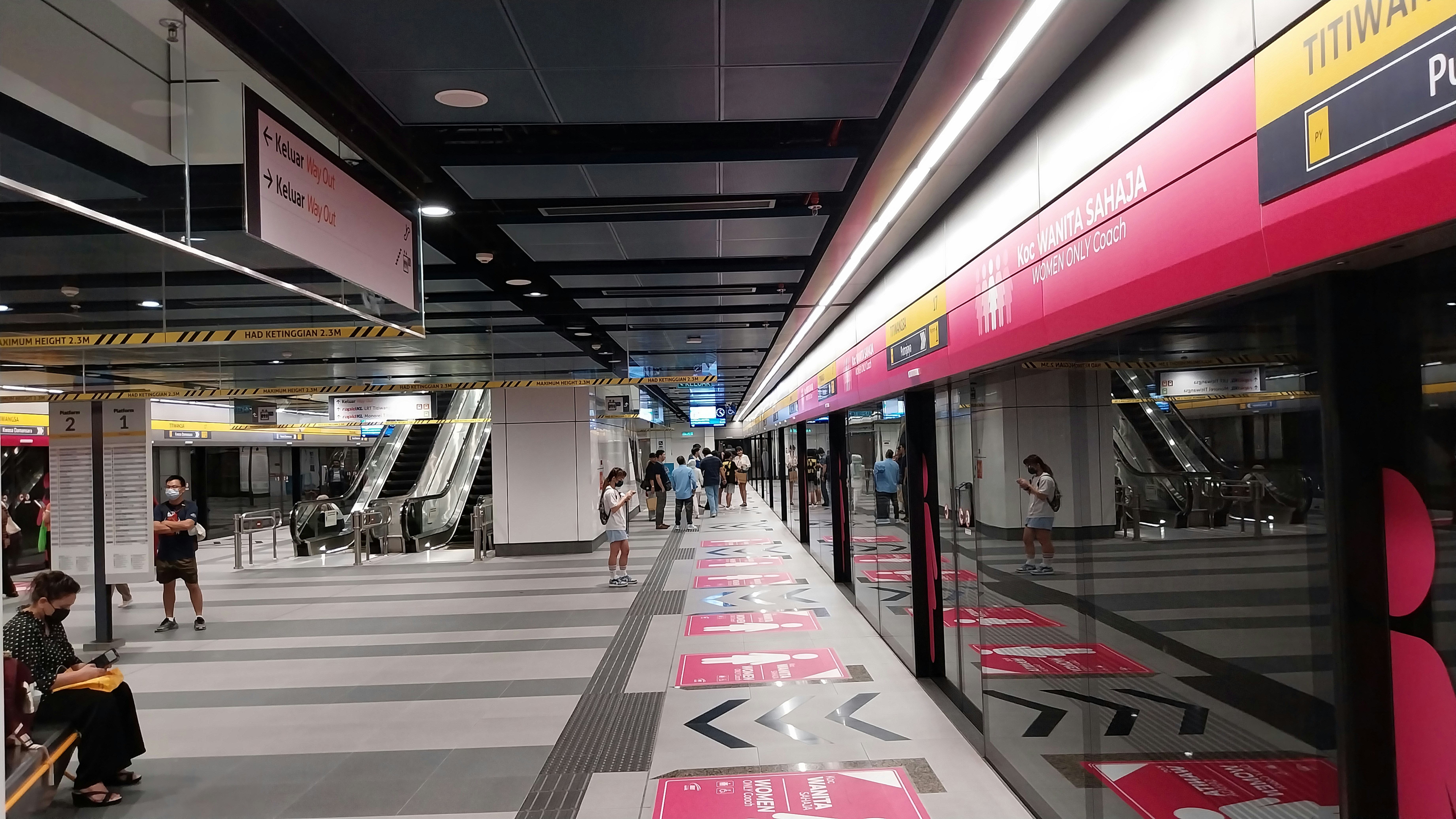 A train station with people waiting for the train