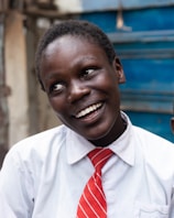 A young boy wearing a red tie and a white shirt