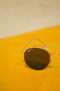 A pair of sunglasses sitting on a yellow blanket