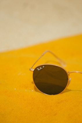 A pair of sunglasses sitting on a yellow blanket