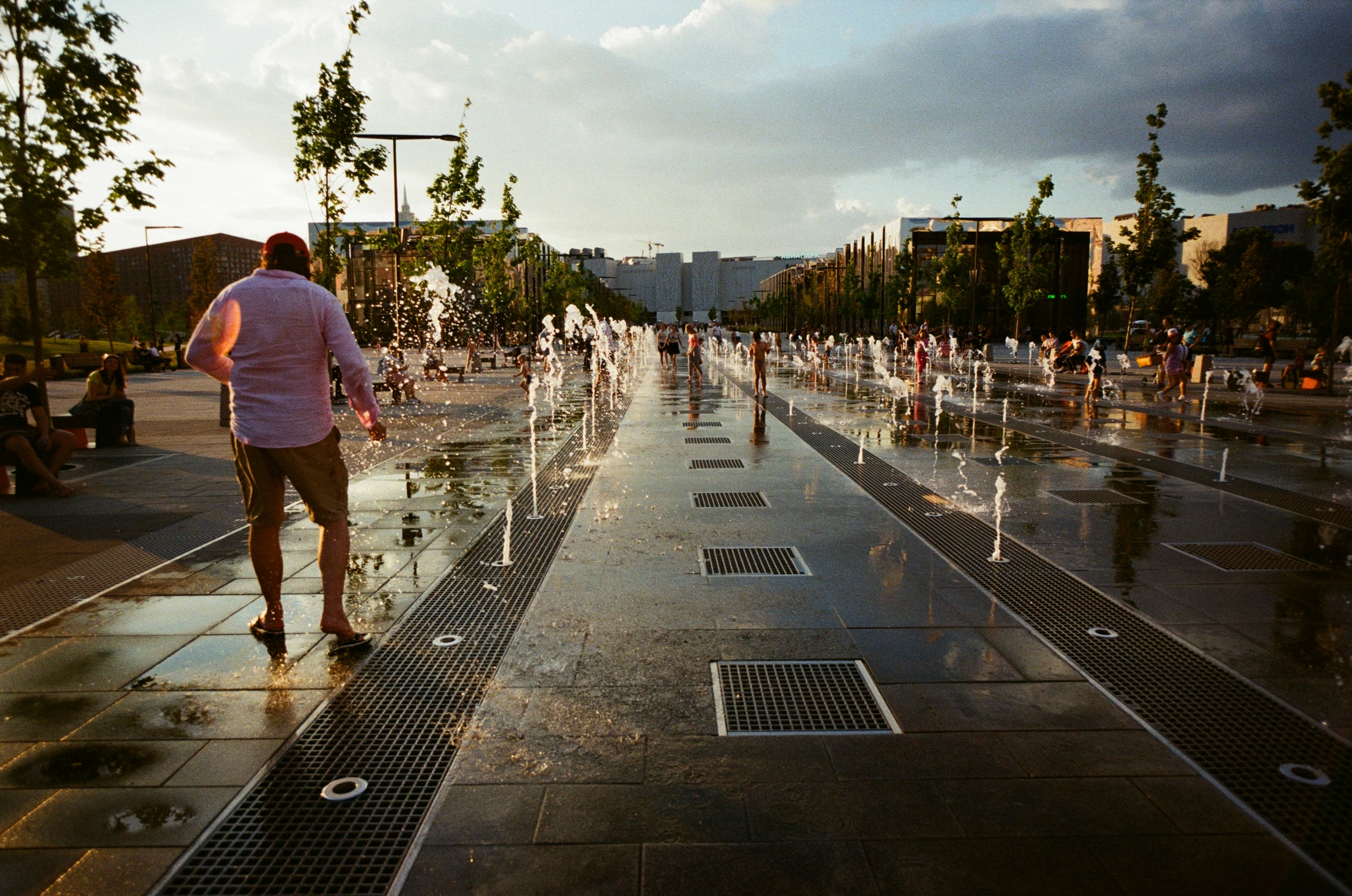 A man is walking down a wet sidewalk