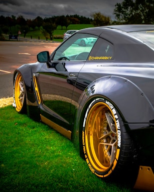 A black and yellow sports car parked in the grass