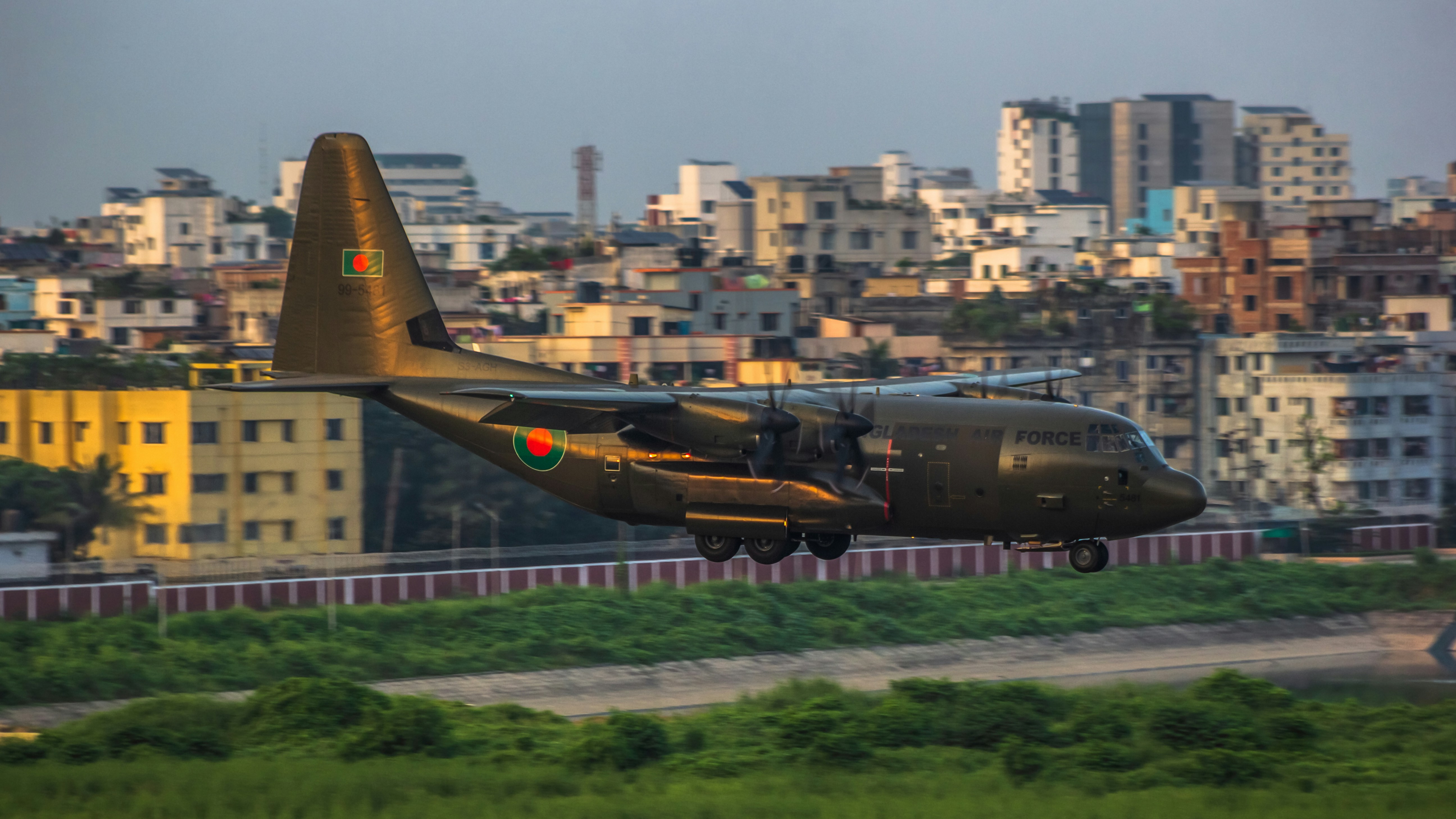 A plane is parked on a runway in front of a city