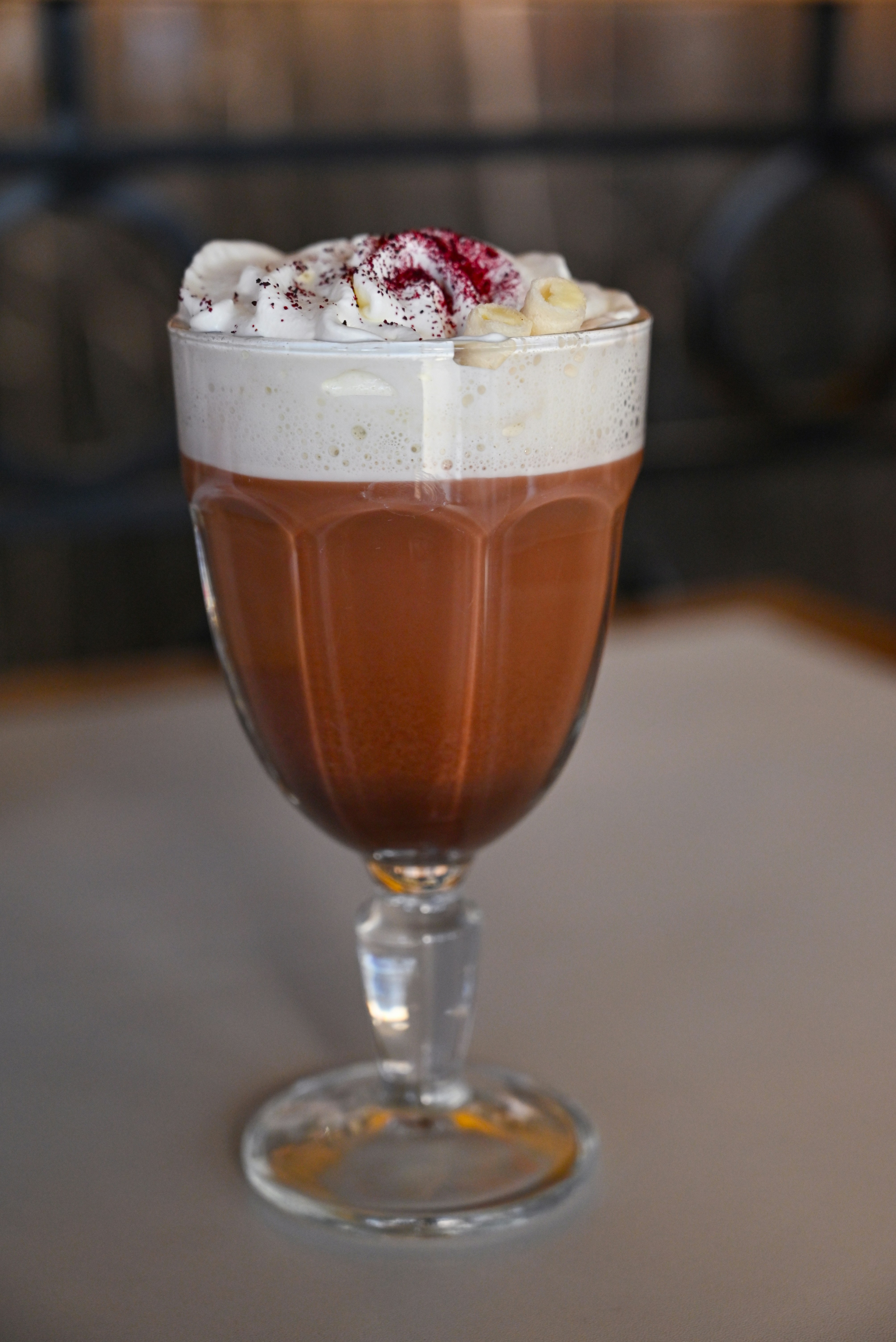 A glass filled with a beverage sitting on top of a table