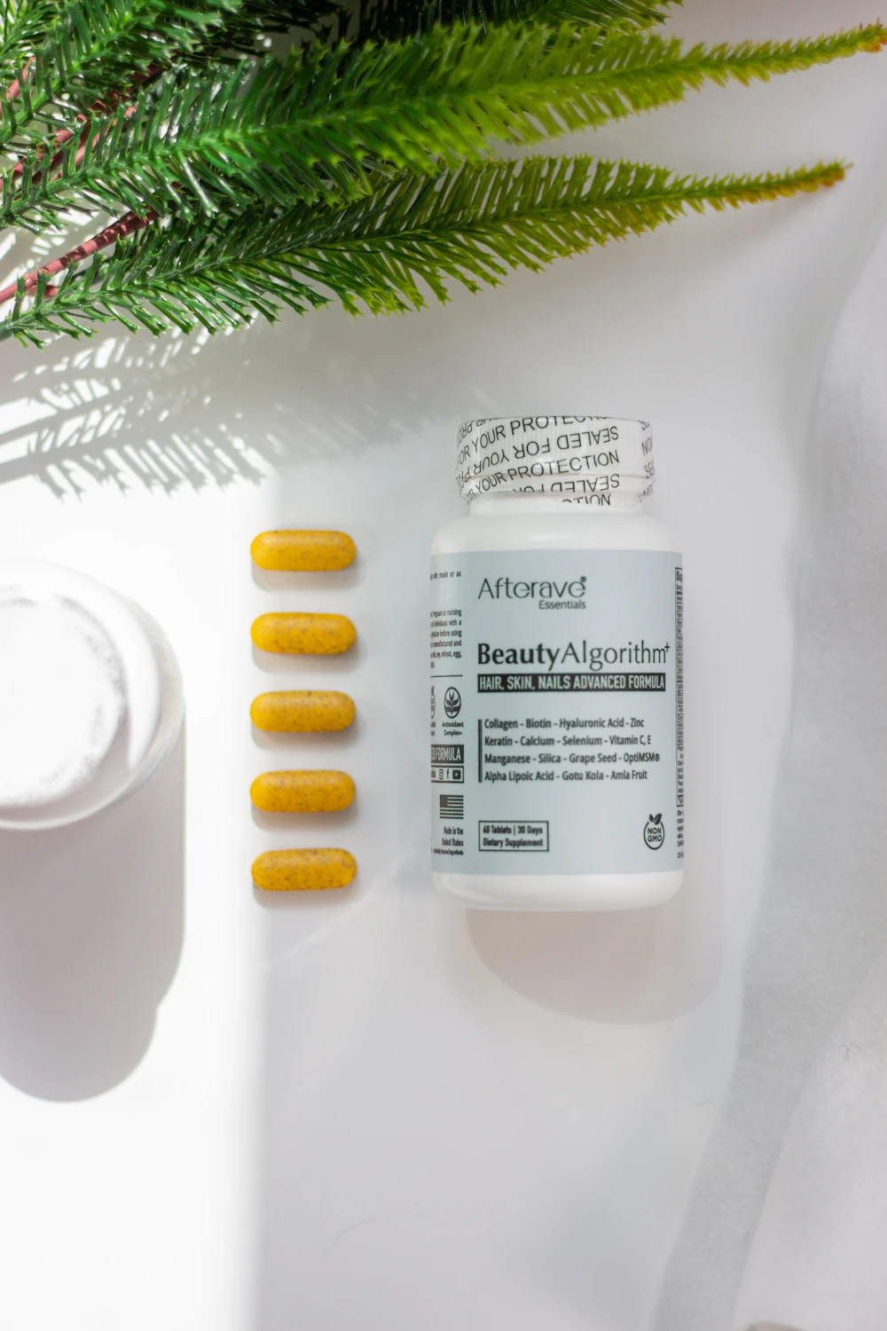 Vitamin supplements beside green foliage
