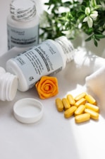 A close up of a bottle of pills next to a flower