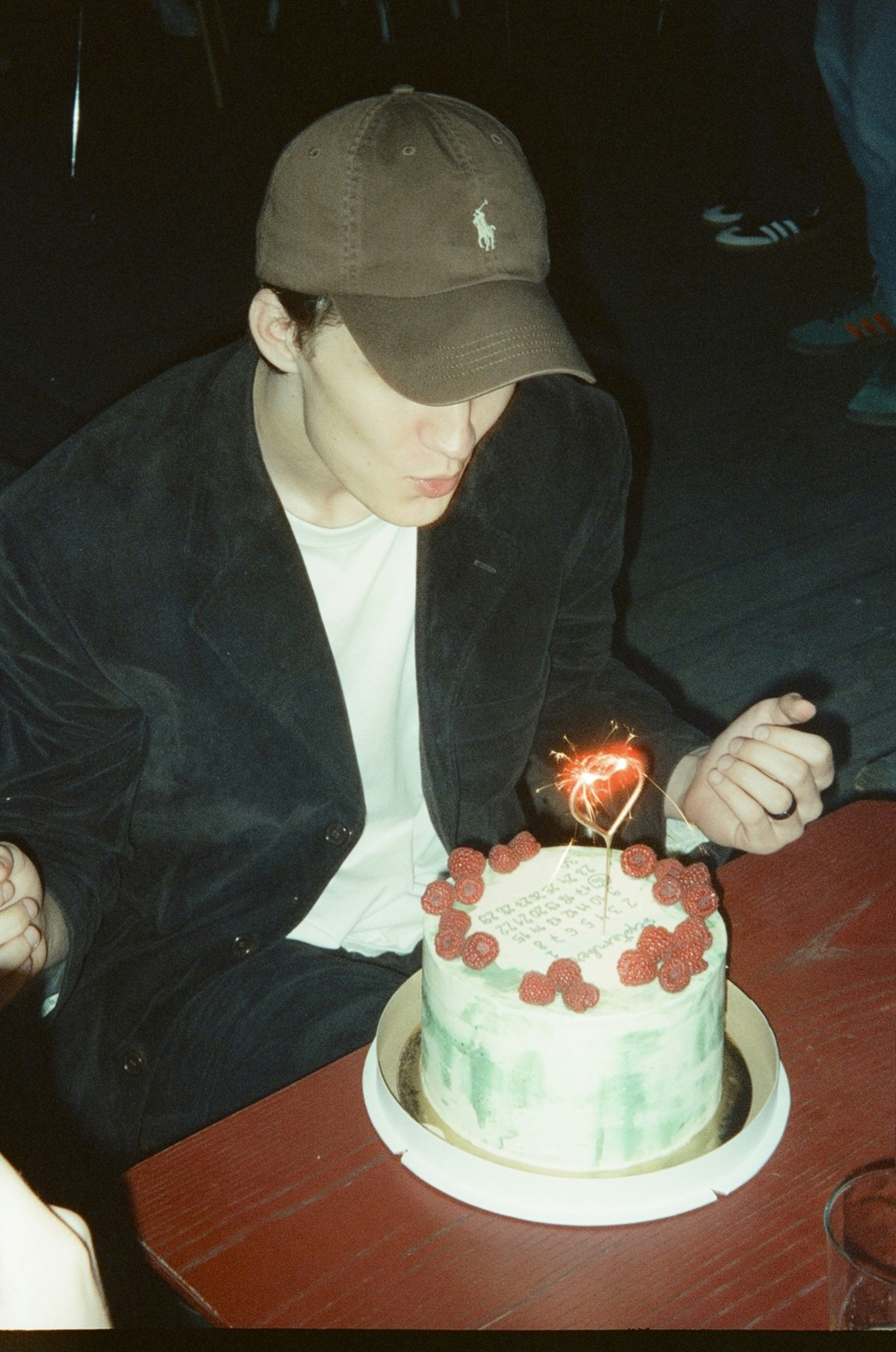 A young man blowing out a candle on a cake