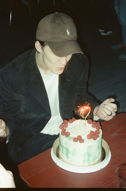 A young man blowing out a candle on a cake