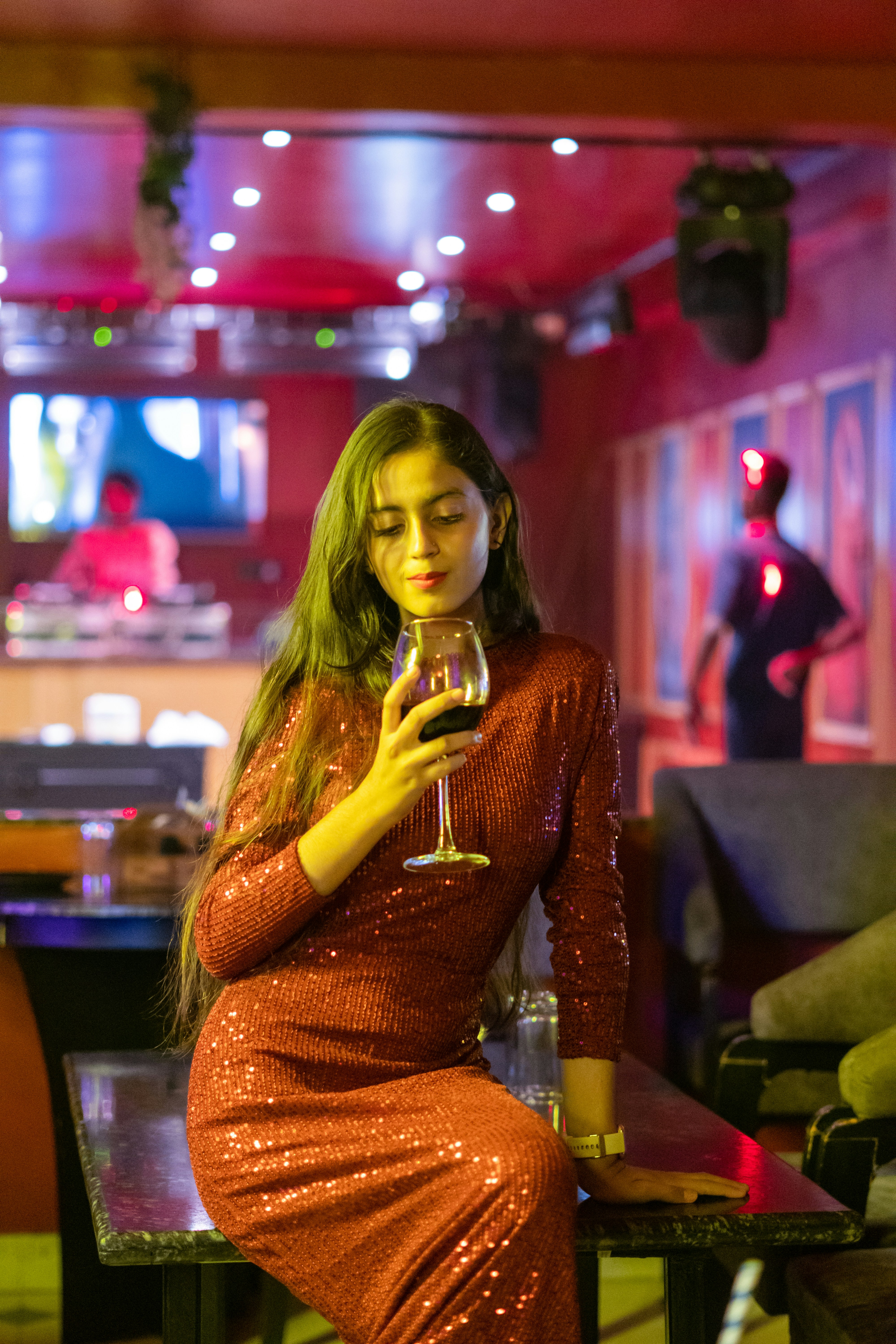 ワインを片手にテーブルに座る女性
