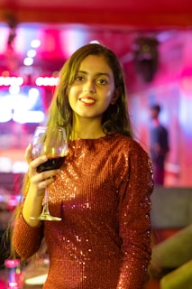 A woman in a red dress holding a glass of wine