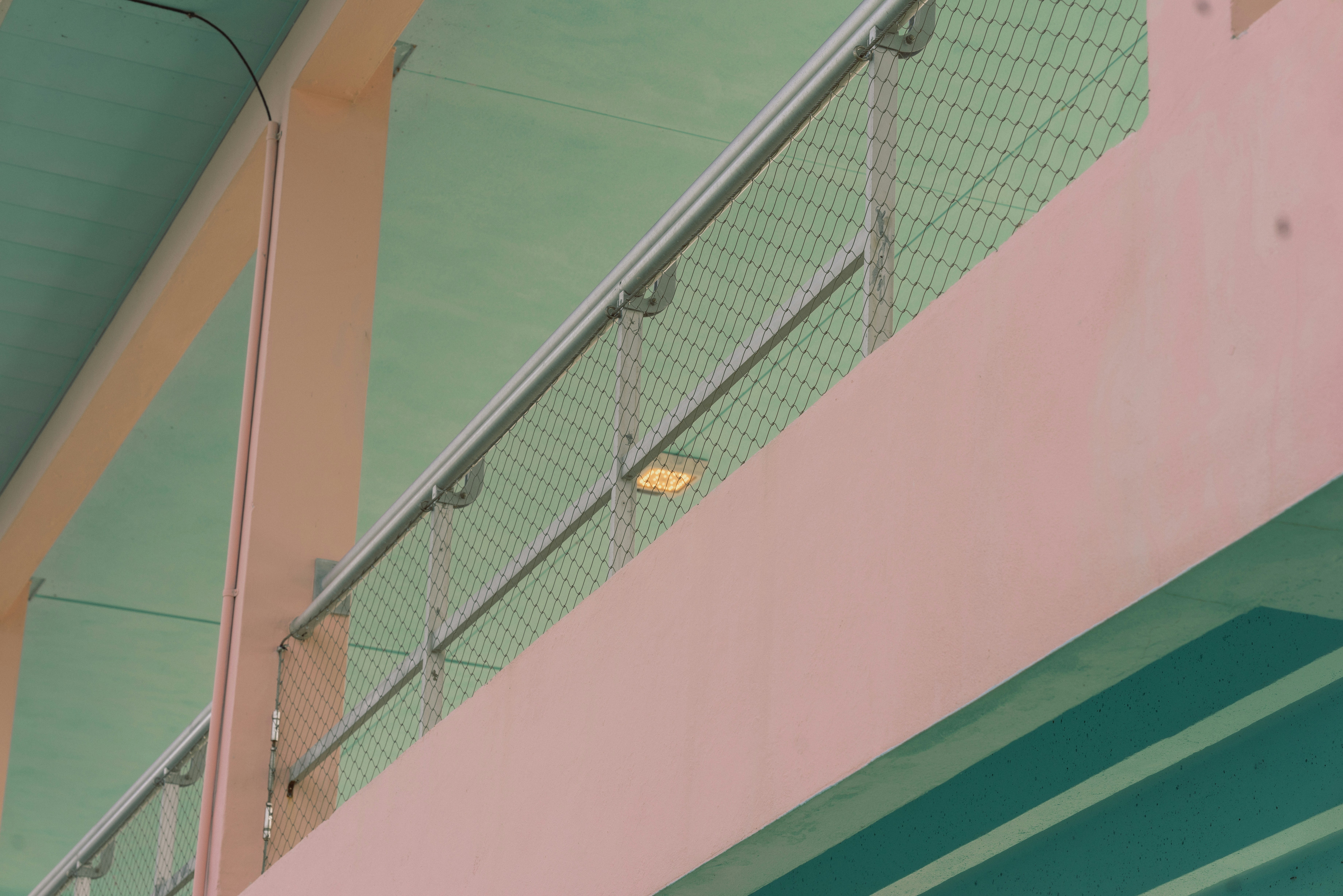 A bird is perched on the railing of a building