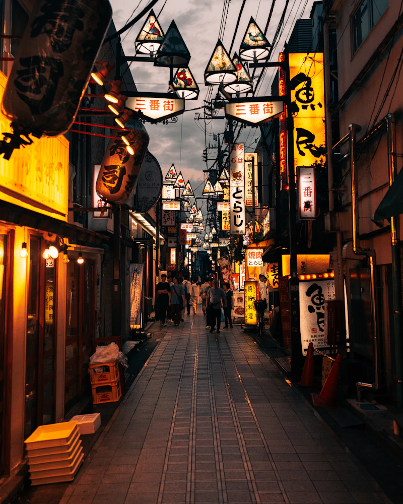 Lanterns over a narrow street in Kyoto at dusk
