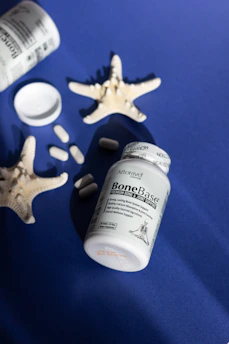 A blue table topped with a bottle of pills and starfish
