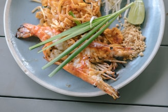A plate of food with shrimp, rice, and lime