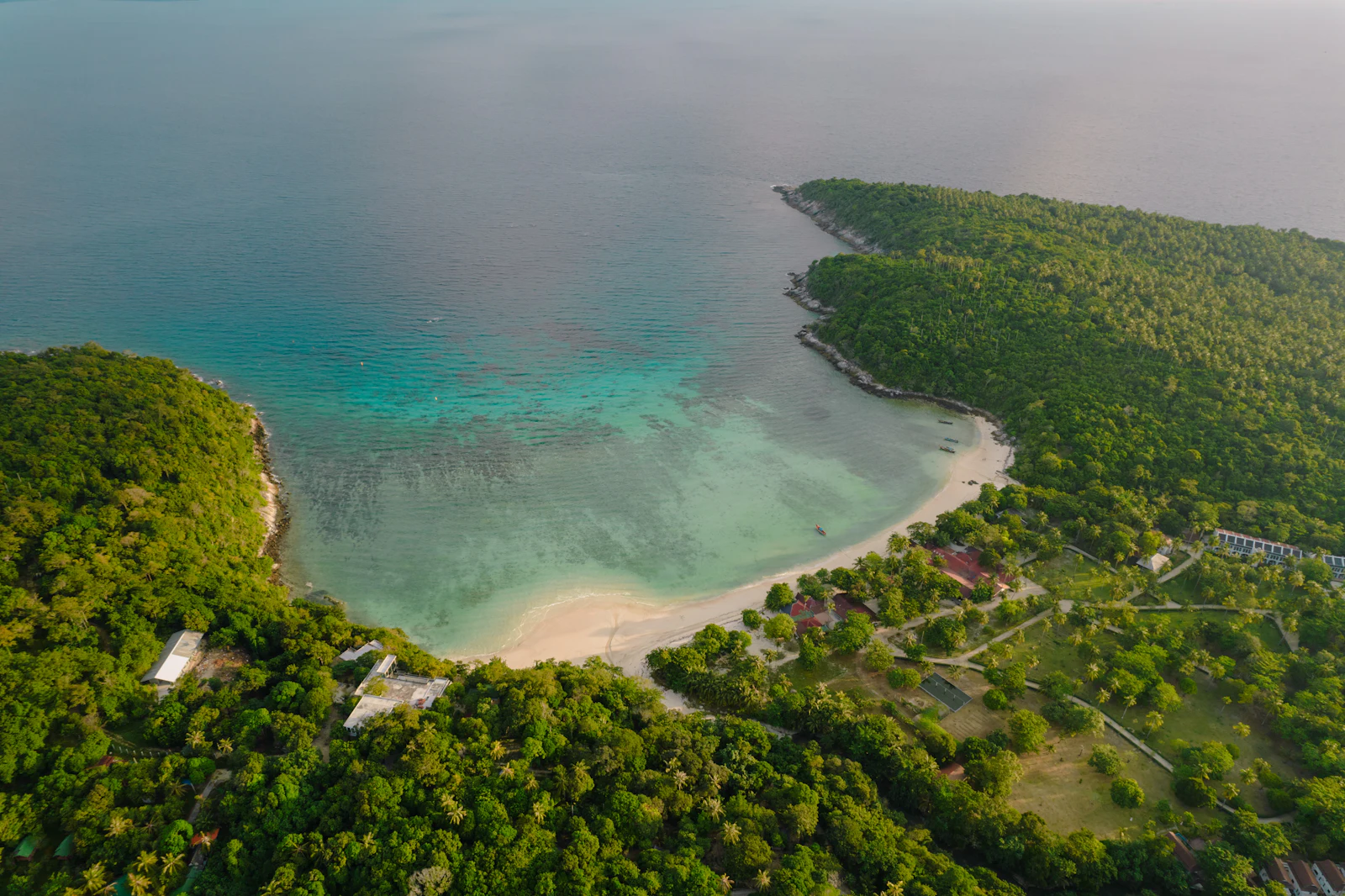 Aerial survey view of a forested headland meeting the sea on Koh Samui