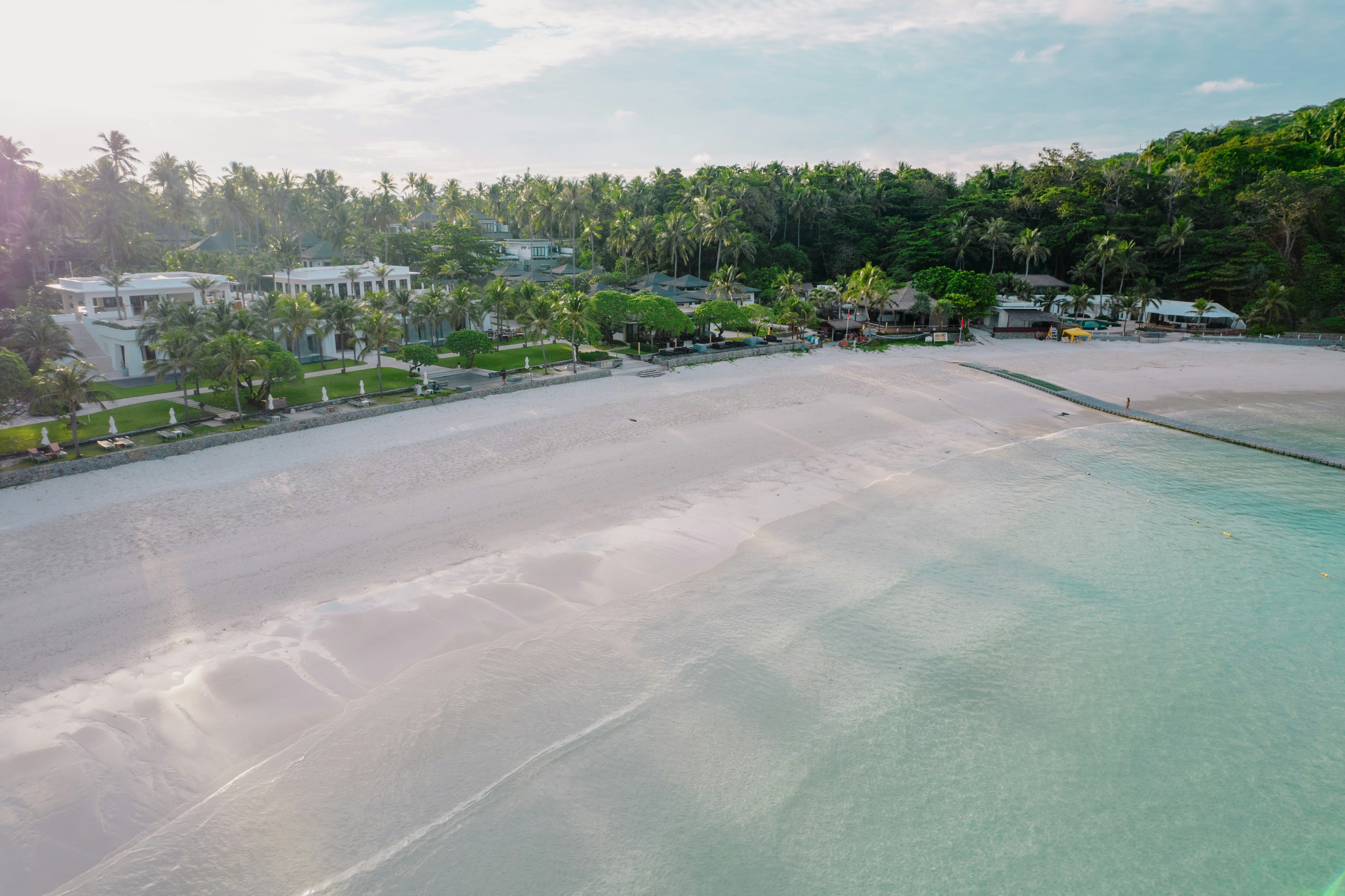 An aerial view of a beach with houses in the background