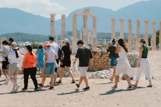 A group of people walking in front of some ruins