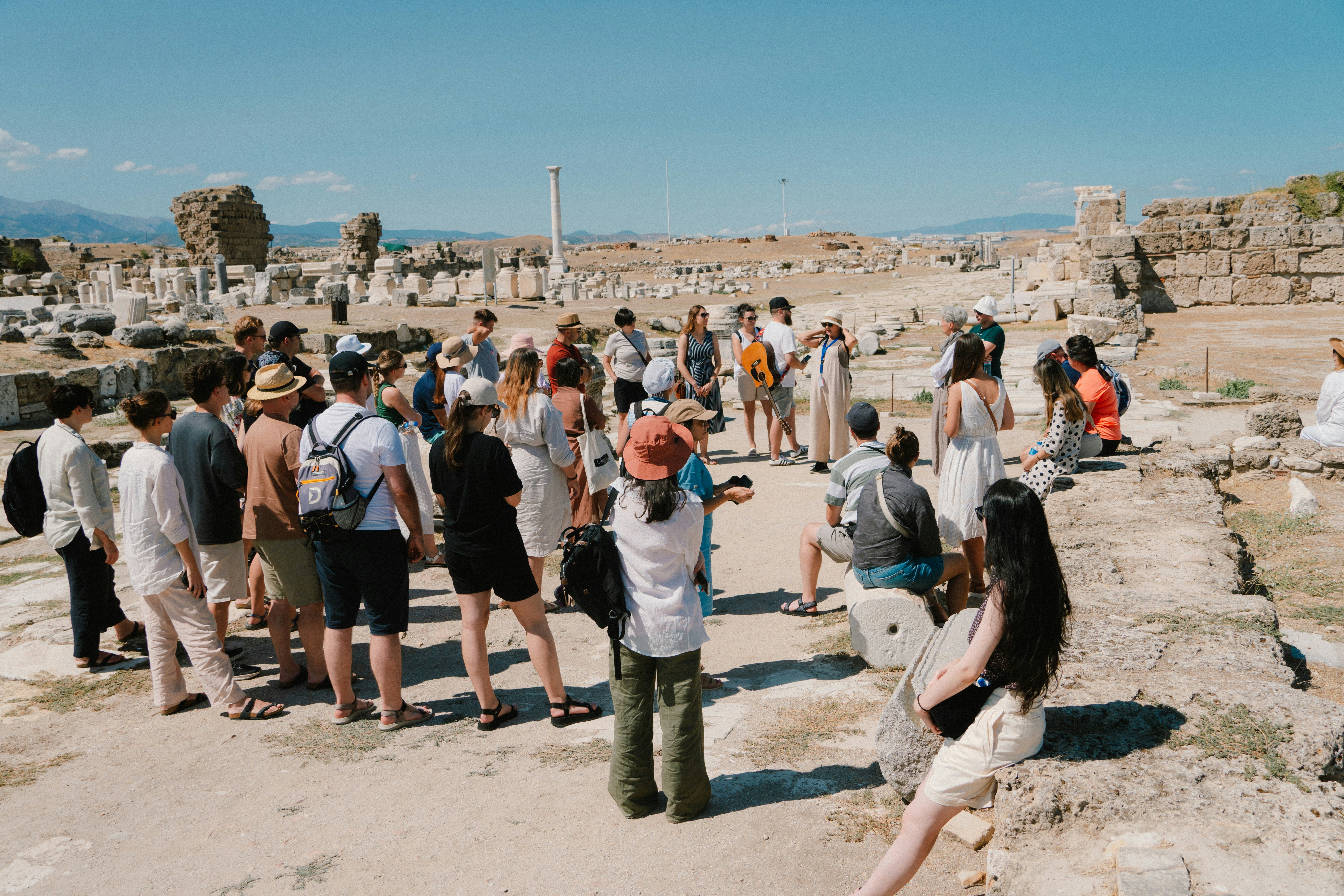 A group of people standing on top of a dirt field