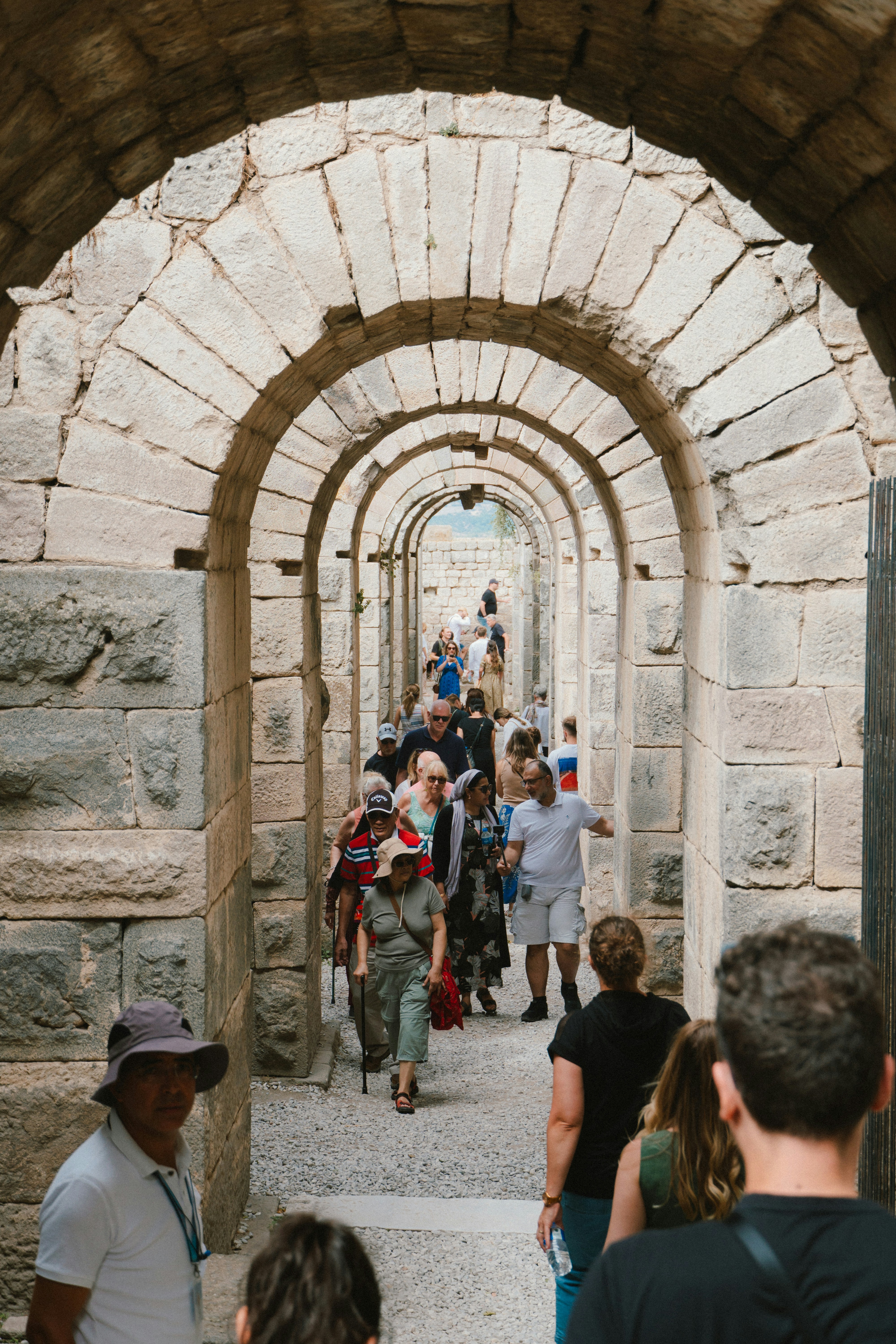 Eine Gruppe von Menschen geht durch einen Steintunnel