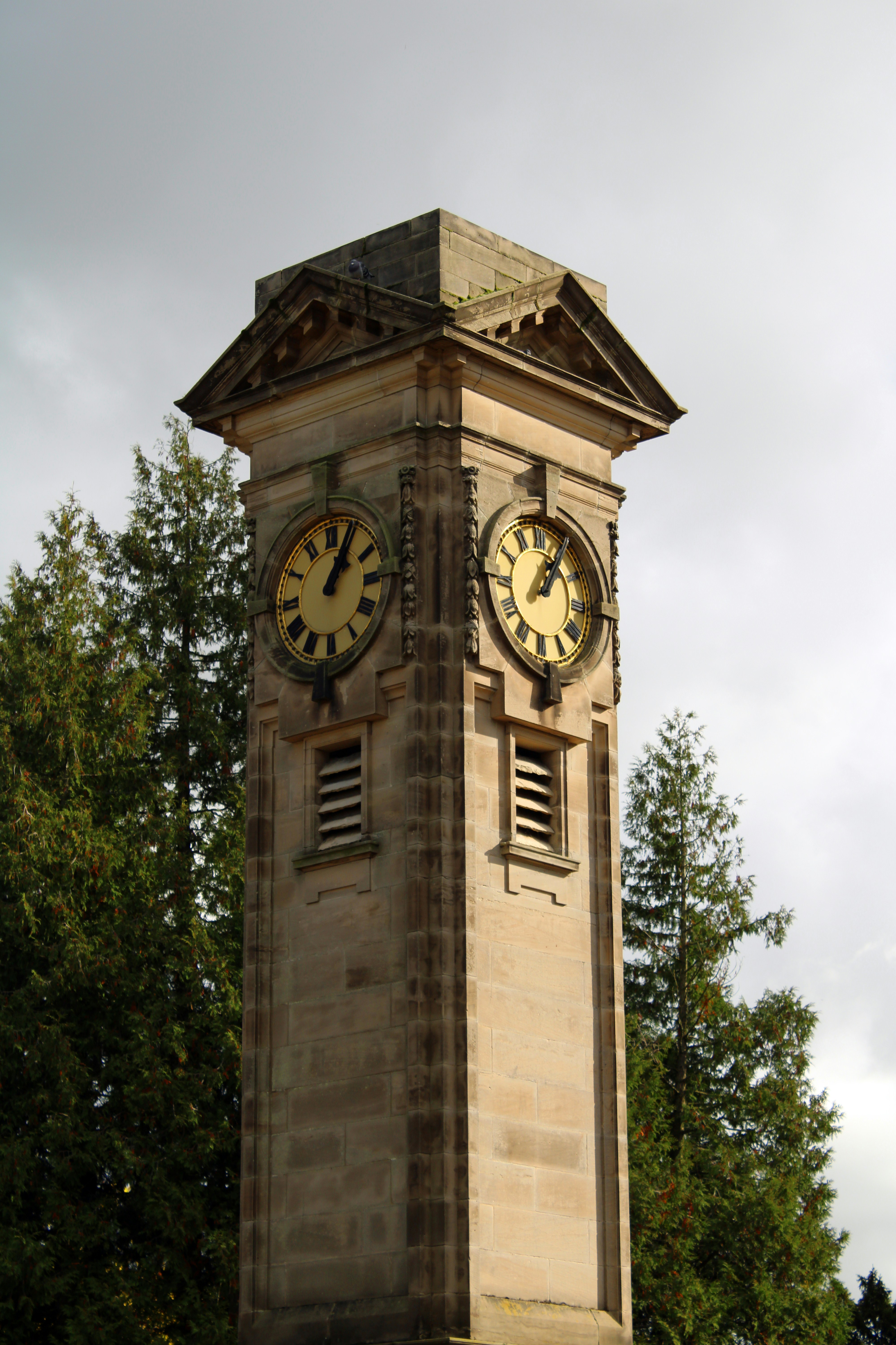 A tall clock tower with two clocks on each of it's sides