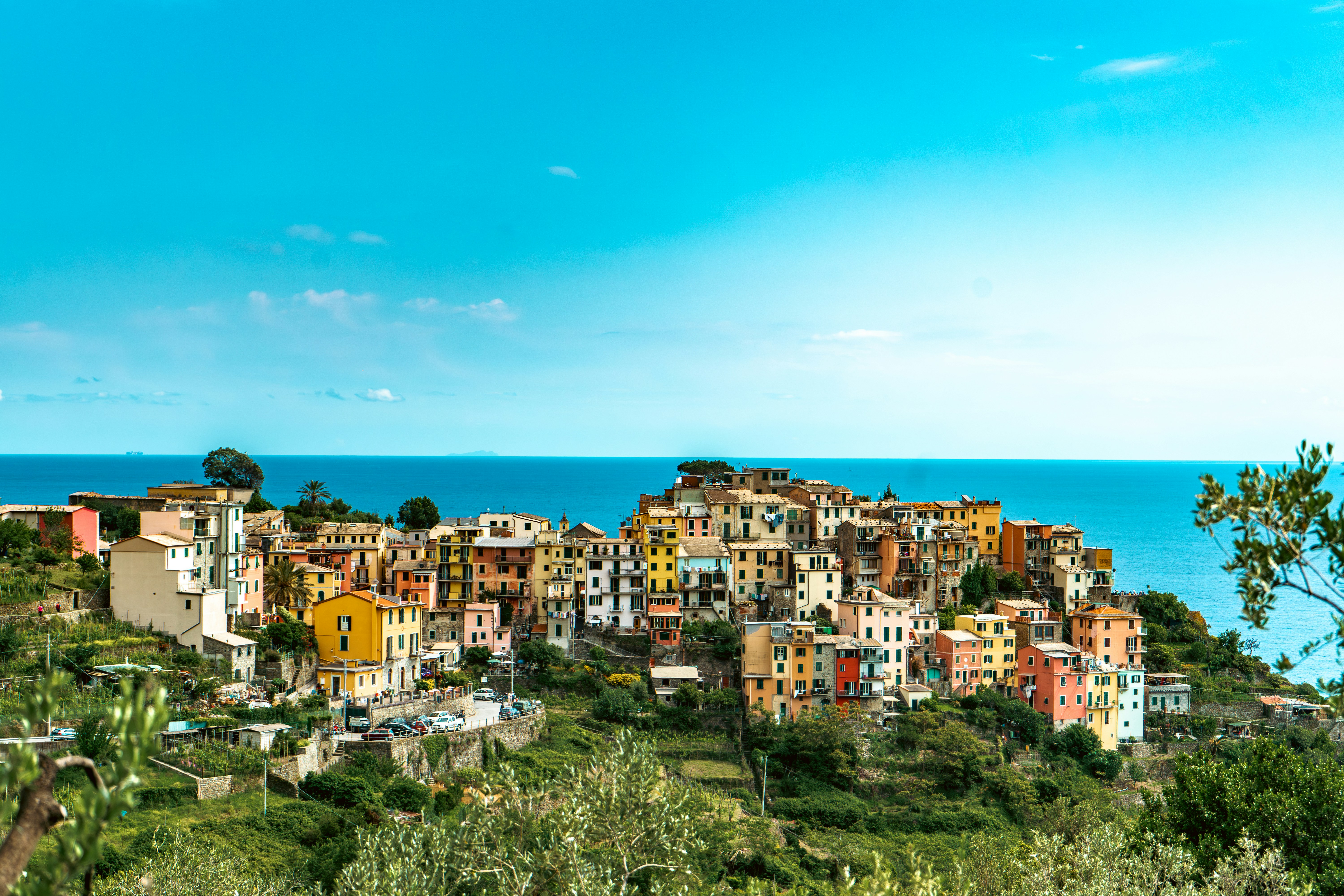 Sweeping view of Corniglia, one of Cinque Terre's charming villages, perched atop rugged cliffs by the Mediterranean Sea.