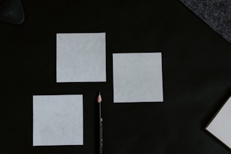 A black table topped with a pencil and paper